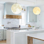 3D printed moon pendant light by DEMOLIGHTS hanging from ceiling, eco-friendly lunar globe chandelier for bedroom decor.