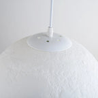 3D printed moon pendant light by DEMOLIGHTS hanging from ceiling, eco-friendly lunar globe chandelier for bedroom decor.