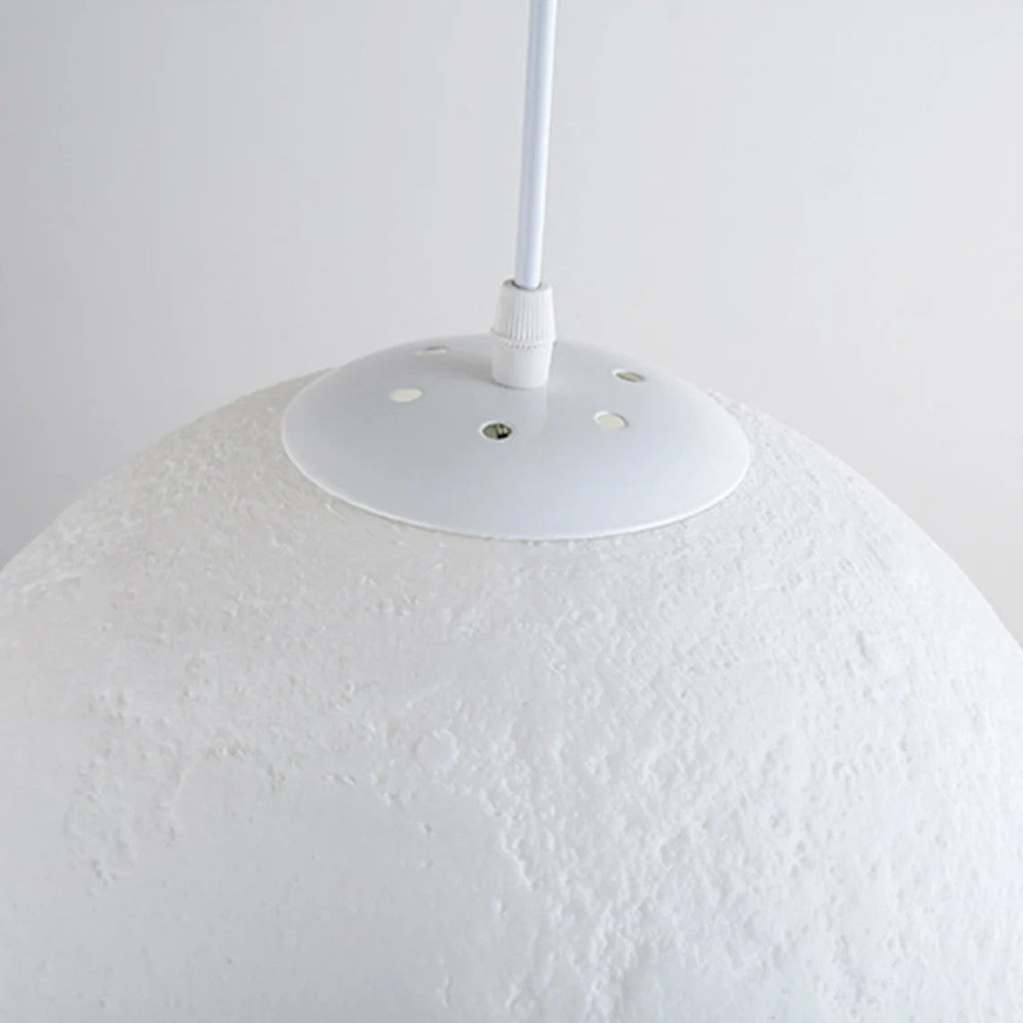 3D printed moon pendant light by DEMOLIGHTS hanging from ceiling, eco-friendly lunar globe chandelier for bedroom decor.