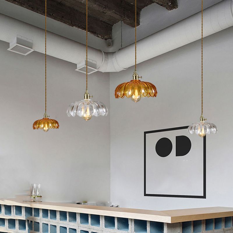 Brass and glass dome pendant light by DEMOLIGHTS hanging from ceiling, showcasing elegant design and modern lighting style.