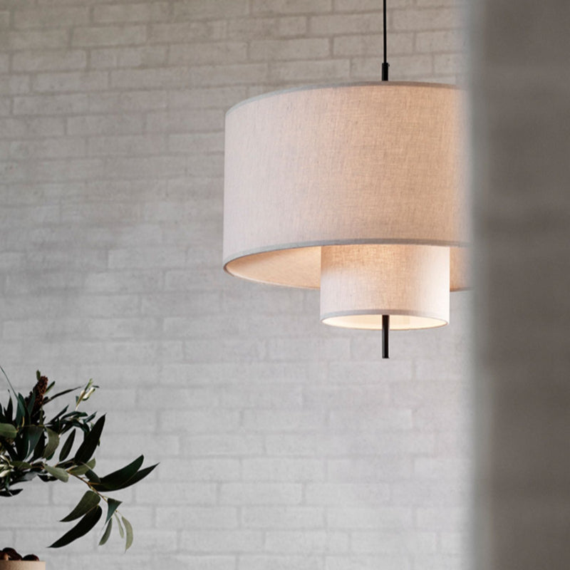 Demolights modern fabric shade pendant light with cylindrical shape hanging from ceiling indoors.