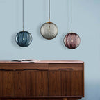 Clear glass ball pendant lamp by DEMOLIGHTS hanging from ceiling, showcasing modern pendant lighting design.
