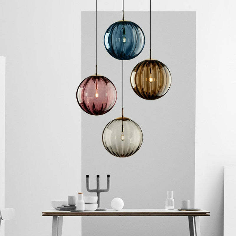 Clear glass ball pendant lamp by DEMOLIGHTS hanging from ceiling with visible cord, modern lighting fixture for stylish interior decor.