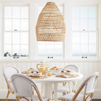 Rattan woven basket pendant lamp shade by DEMOLIGHTS hanging with a warm glow, ideal for rustic or boho interior lighting.