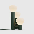 Minimalist DEMOLIGHTS 3-light table lamp with red, green, and white shades on a sleek base, ideal for modern home decor.
